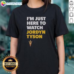 Alt Text: Top featuring Jordyn Tyson's 'Im Just Here To Watch' graphic design on a ladies tee, perfect for casual wear.