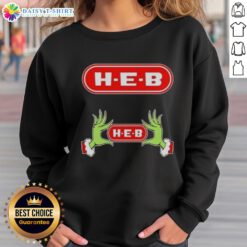 Awesome Grinch hands on a festive H-E-B Christmas sweatshirt, perfect for holiday cheer and seasonal celebrations.
