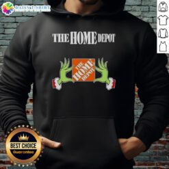 Awesome Grinch hands holding The Home Depot Christmas hoodie, perfect for festive holiday celebrations and gift giving.