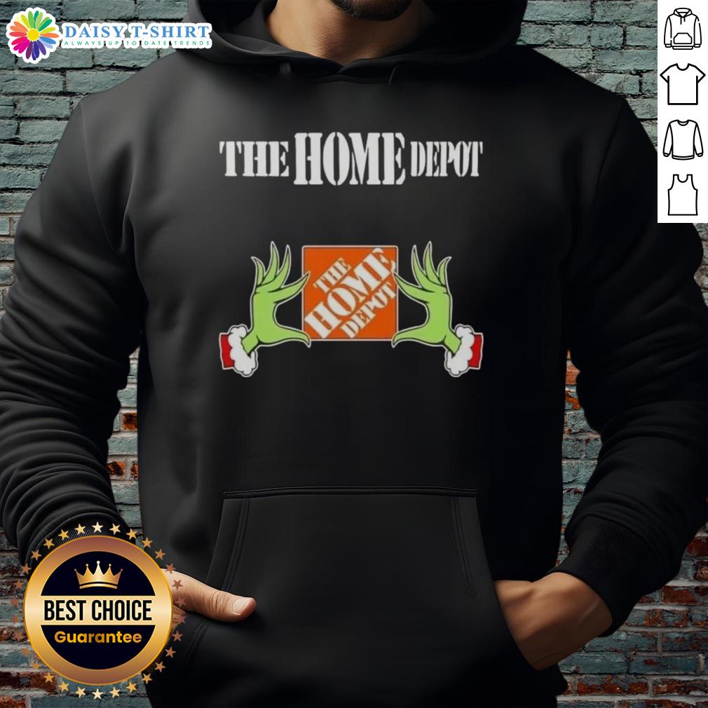 Awesome Grinch hands holding The Home Depot Christmas hoodie, perfect for festive holiday celebrations and gift giving.