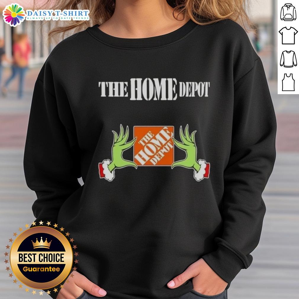 Alt Text: Awesome Grinch hands holding a mug, featuring The Home Depot Christmas sweatshirt design in festive colors.