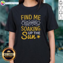 Happy woman in a 'Find Me Outside Soaking Up The Sun' tee, enjoying a sunny day outdoors, radiating joy and positivity.