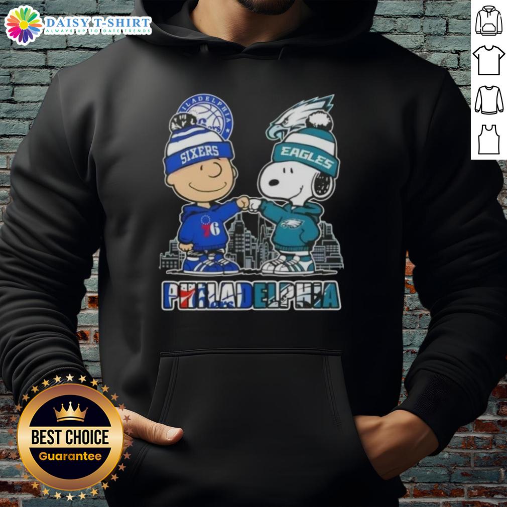 Alt Text: Cute Charlie Brown fist bump with Snoopy in Philadelphia skyline hoodie featuring 76ers and Eagles logos.