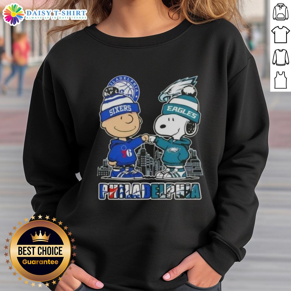Adorable Charlie Brown fist bump with Snoopy on a Philadelphia skyline sweatshirt for 76ers and Eagles fans.