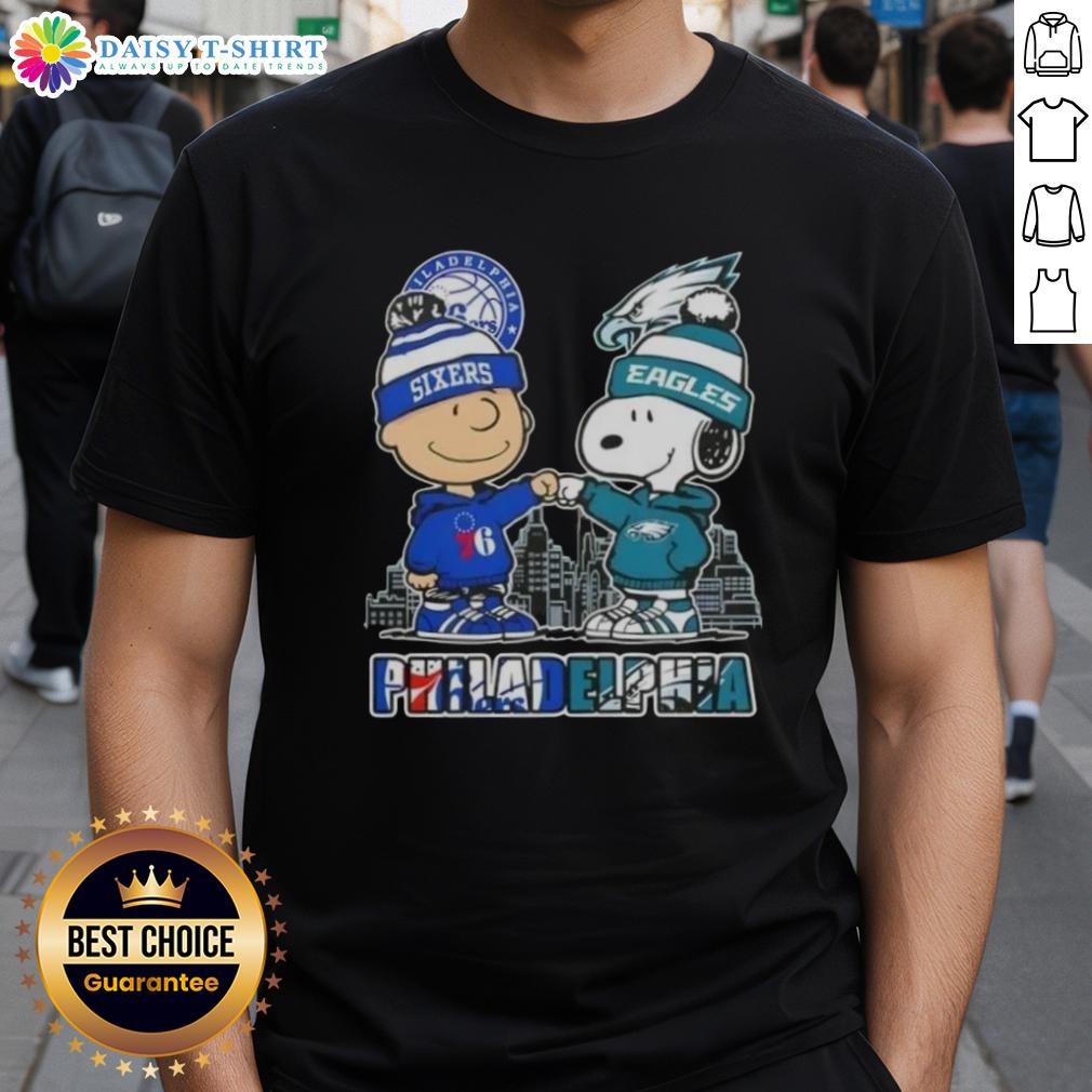 Cute Charlie Brown fist bump with Snoopy on Philadelphia 76ers x Eagles skyline T-shirt, perfect for sports fans.
