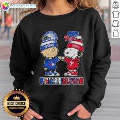 Alt Text: Cute Charlie Brown fist bump with Snoopy on 76ers x Phillies sweatshirt, perfect for Philadelphia sports fans.
