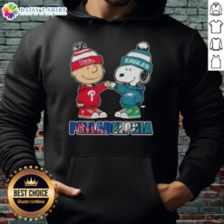 Cute Charlie Brown fist bump with Snoopy in a Philadelphia sports hoodie featuring Phillies and Eagles logos.