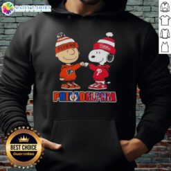 Cute Charlie Brown fist bump with Snoopy in Philadelphia sports hoodie featuring Phillies and Flyers designs.