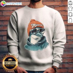 Miami Dolphins mascot wearing a beanie, sunglasses, and a sweatshirt, showcasing team spirit in a fun outfit.