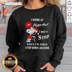 Cozy Christmas sweatshirt featuring Snoopy with the phrase 'I work at Pizza Hut, I don't stop when I'm tired'.