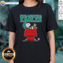 Alt Text: Official Philadelphia Eagles Snoopy relaxing with a football in Peanuts style on a ladies tee, perfect for fans.