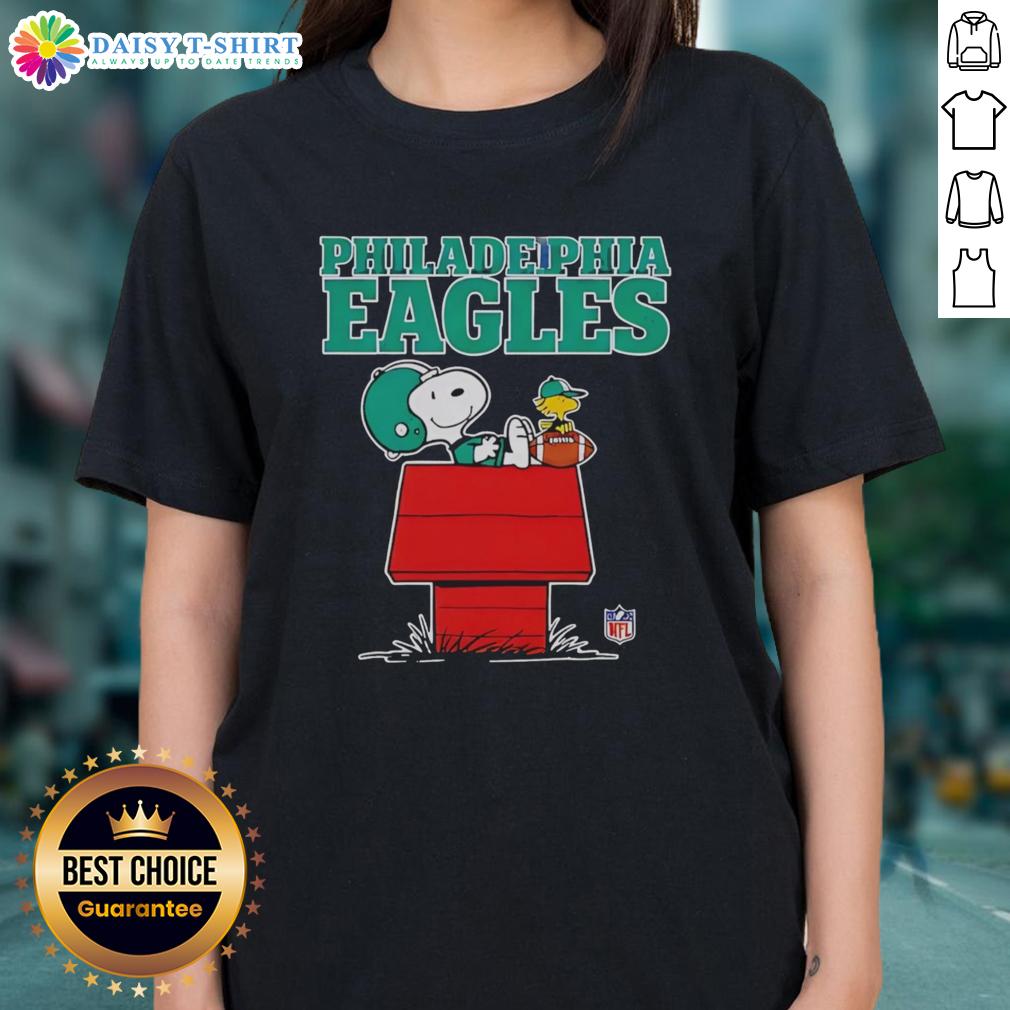 Alt Text: Official Philadelphia Eagles Snoopy relaxing with a football in Peanuts style on a ladies tee, perfect for fans.