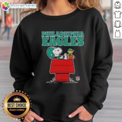 Official Philadelphia Eagles Snoopy sweatshirt featuring Snoopy chilling with a football in Peanuts style.