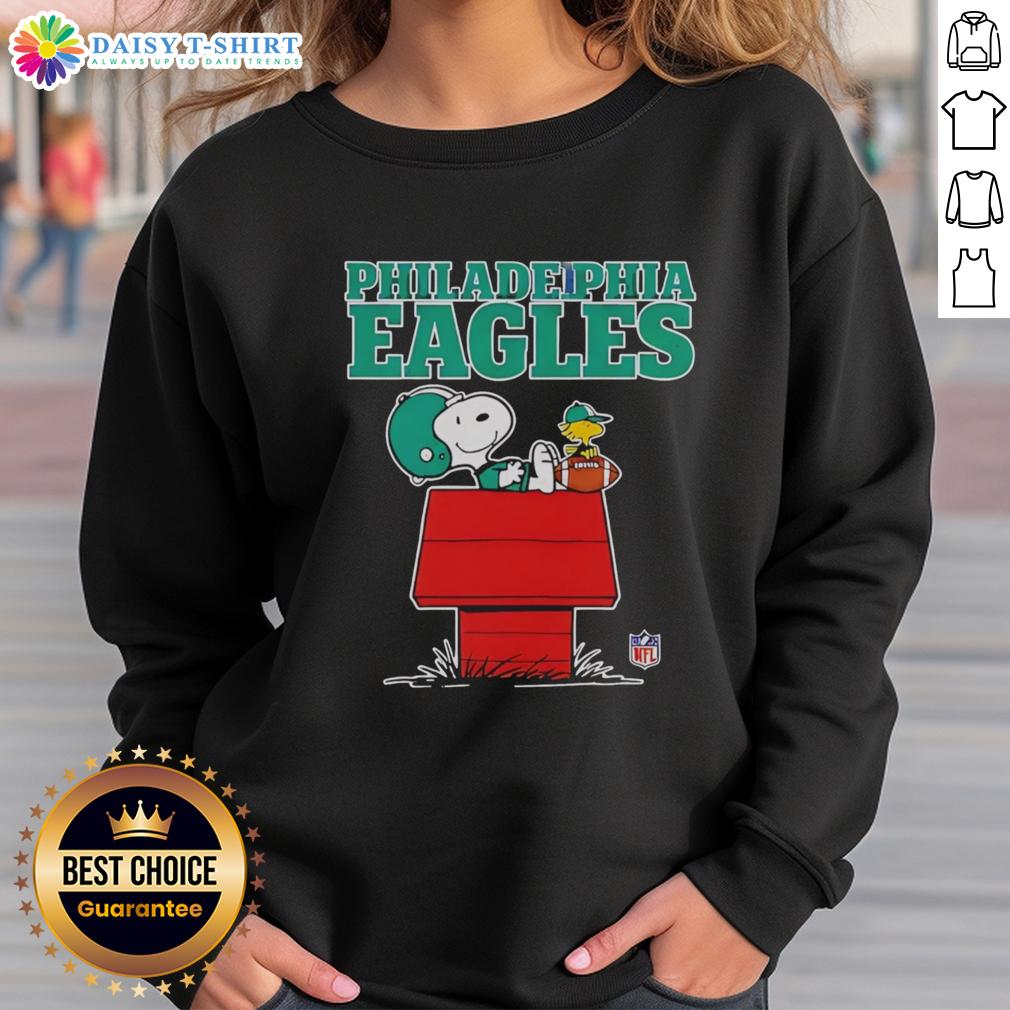 Official Philadelphia Eagles Snoopy sweatshirt featuring Snoopy chilling with a football in Peanuts style.