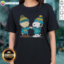 Charlie Brown and Snoopy fist bump in a Jacksonville Jaguars football ladies tee design featuring peanuts theme.