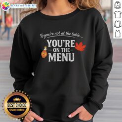 Nice If You're Not At The Table You're On The Menu sweatshirt, featuring bold text design on a cozy garment.