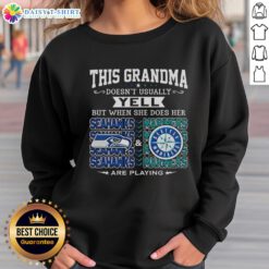 Grandma wearing a Seattle Seahawks and Mariners sweatshirt, excitedly cheering at a game, showcasing team spirit.