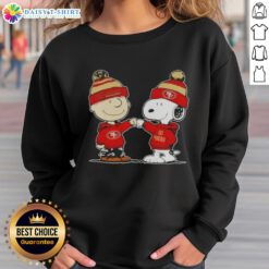 Charlie Brown and Snoopy fist bump in a San Francisco 49ers sweatshirt, celebrating friendship and football spirit.