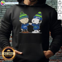 Charlie Brown and Snoopy fist bump in Seattle Seahawks football hoodie, celebrating teamwork and fandom.