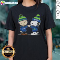 Charlie Brown and Snoopy fist bump in Seattle Seahawks football ladies tee featuring Peanuts characters.
