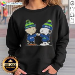 Charlie Brown and Snoopy fist bump in Seahawks sweatshirt, celebrating football spirit in a fun Peanuts design.