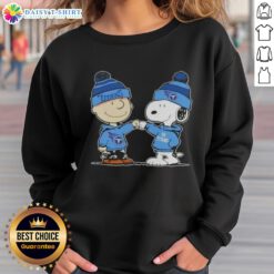 Charlie Brown and Snoopy fist bump in Tennessee Titans football sweatshirt, showcasing fun Peanuts teamwork spirit.