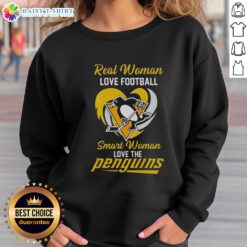 Smart woman wearing a heart sweatshirt, showing love for the Pittsburgh Penguins while enjoying football.