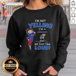 Girl wearing an 'I'm Not Yelling, I'm Kansas Jayhawks' sweatshirt, showcasing team spirit and casual style.