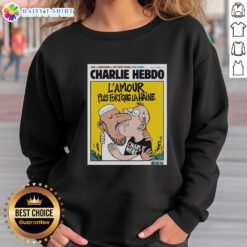 Two men kissing in 'L'Amour Plus Fort Que La Haine' sweatshirt, symbolizing love and unity after Charlie Hebdo.
