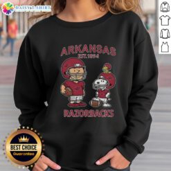 Alt Text: Official Charlie Brown and Snoopy Arkansas Razorbacks NCAA Football sweatshirt, celebrating Est. 1894 style and fandom.