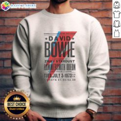 David Bowie performing as Ziggy Stardust at Hammersmith Odeon, wearing a vibrant sweatshirt, capturing a legendary moment.